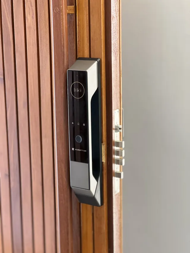 Fechadura digital com leitor facial instalada em porta ripada de madeira
